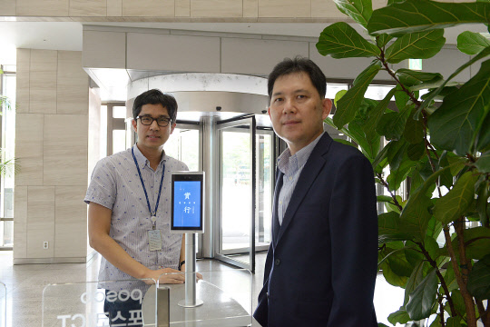 김주한(오른쪽)포스코ICT 안면인식솔루션 사업총괄 팀장과 김수상 AI·빅데이터개발그룹 팀장이 성남 판교 포스코ICT 사옥에 설치된 안면인식 단말기 앞에서 포즈를 취하고 있다.  포스코ICT 제공